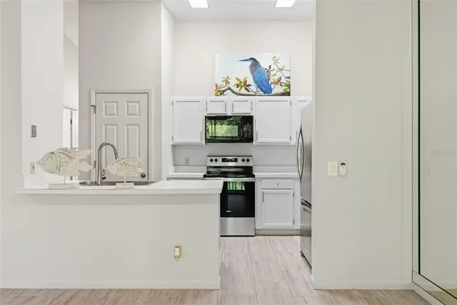 a kitchen with stainless steel appliances a stove a sink and a refrigerator