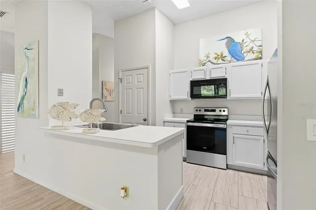 a kitchen with stainless steel appliances white cabinets and a refrigerator