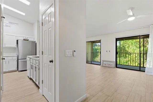 an empty room with windows and a ceiling fan