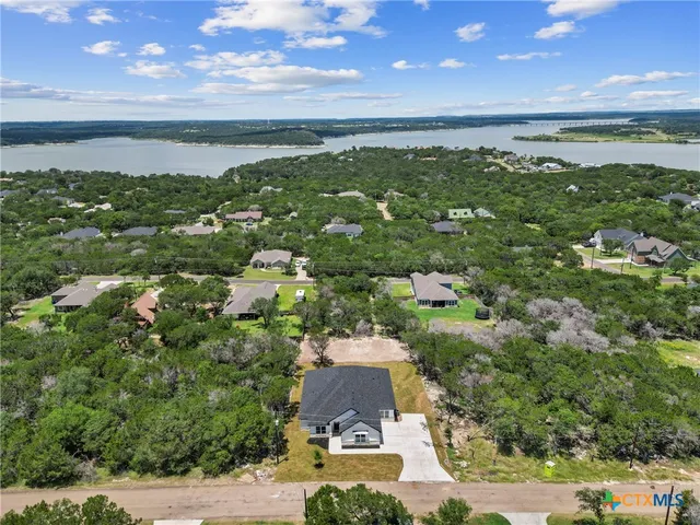 an aerial view of residential houses with outdoor space and trees