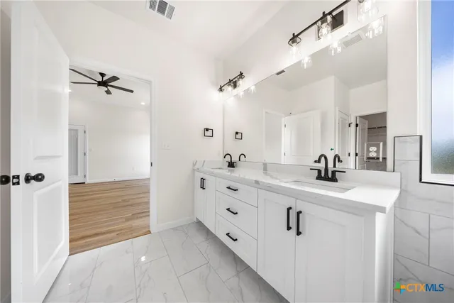 a view of a livingroom with a ceiling fan & window