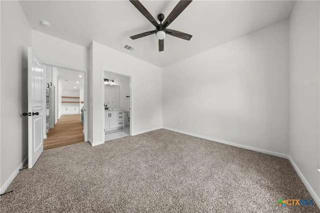 an empty room with windows and ceiling fan