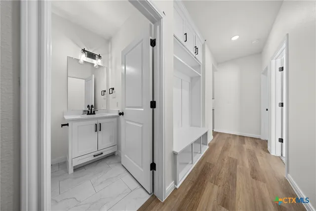 a bathroom with a granite countertop sink a toilet a mirror and bathtub