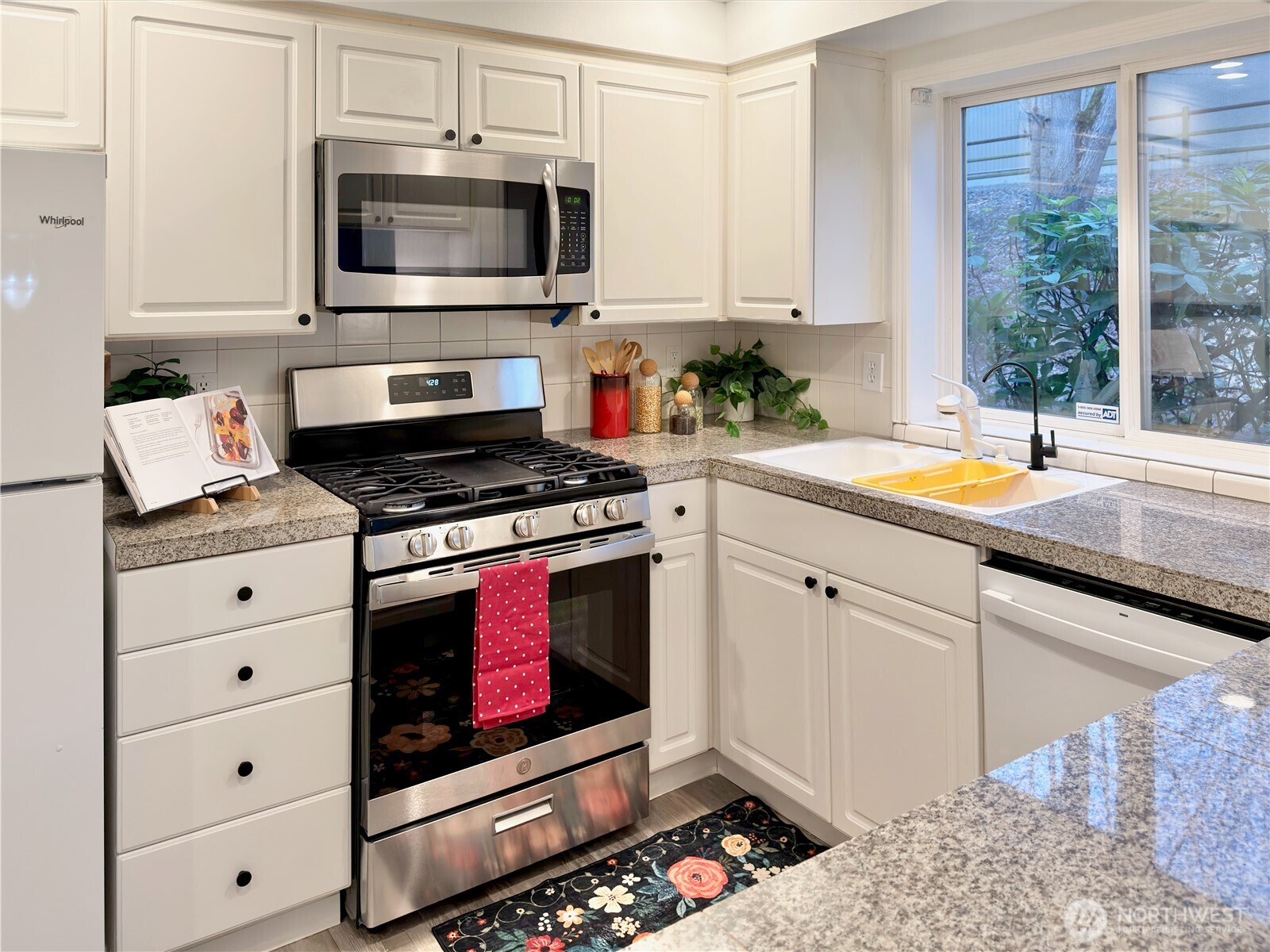 210 10th Street, Unit 4 Kirkland, WA 98033 - Photo 11 of 35 a kitchen with stainless steel appliances kitchen island granite countertop a stove a sink and a microwave