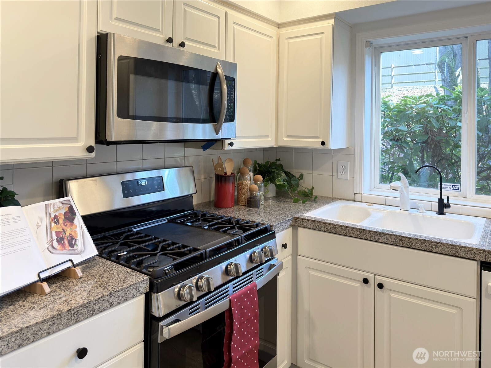210 10th Street, Unit 4 Kirkland, WA 98033 - Photo 12 of 35 a kitchen with stainless steel appliances granite countertop a sink stove and microwave