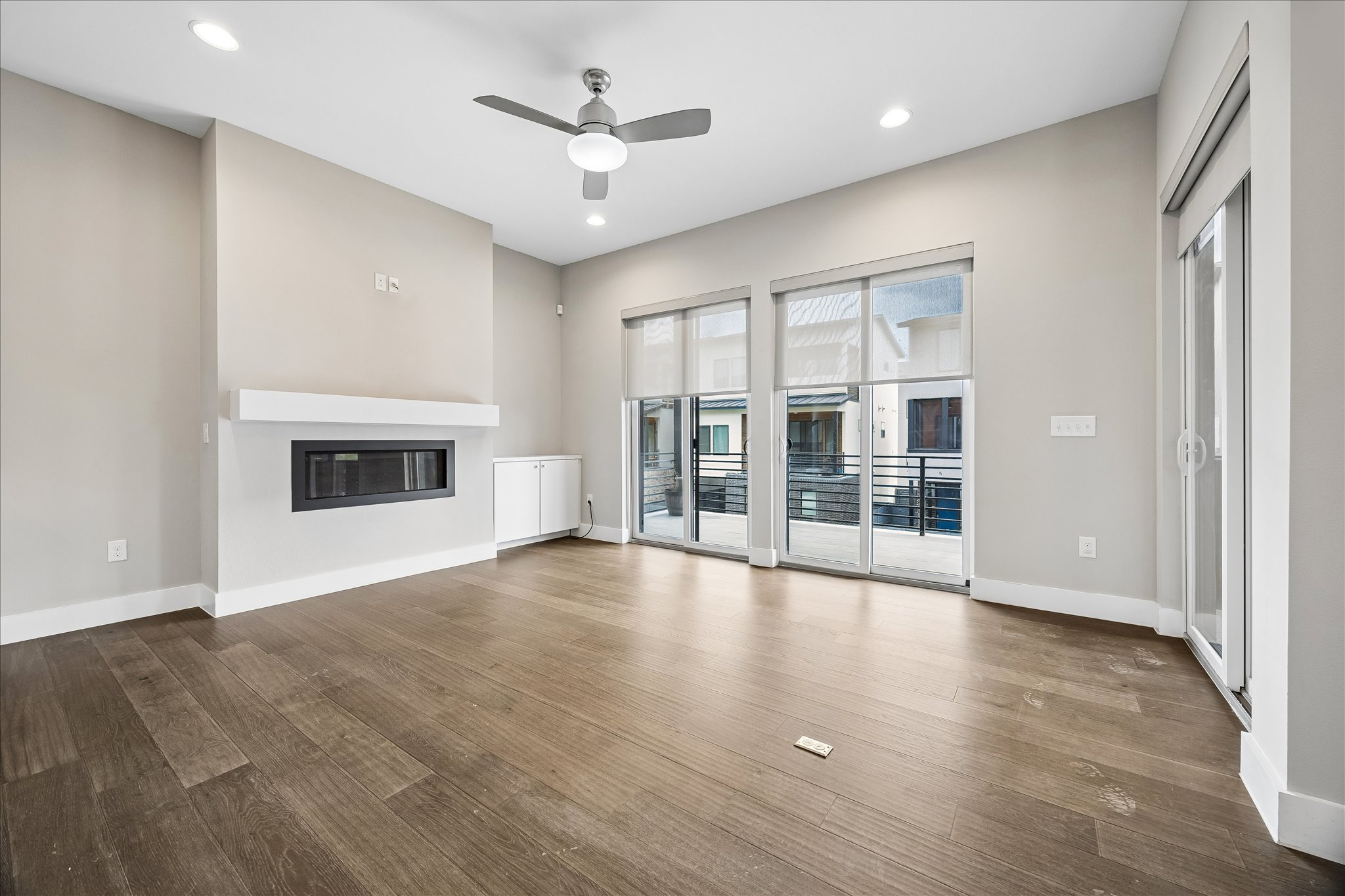 5006 Pecan Springs Road, Unit 6 Austin, TX 78723 - Photo 6 of 30 A contemporary living area with hardwood floors and a sleek fireplace, opening to a balcony.