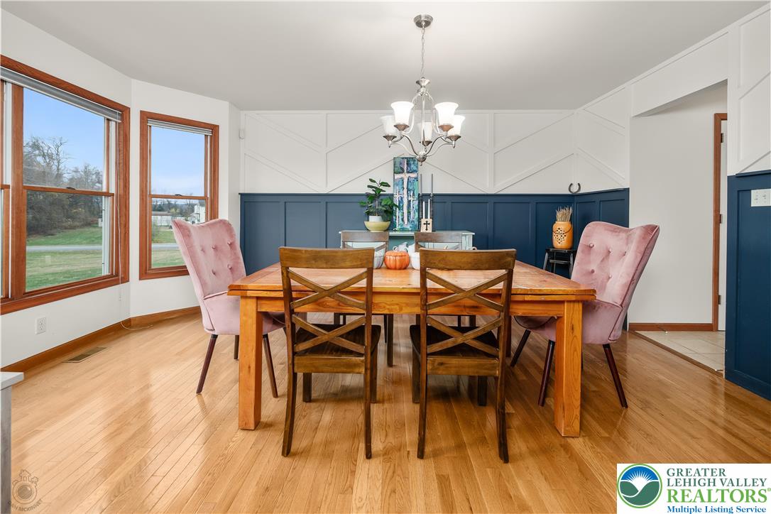 5 Farmstead Way Mount Bethel, PA 18343 - Photo 5 of 37 a dining room with furniture wooden floor a rug a potted plant and a chandelier
