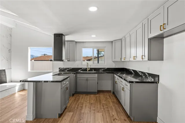 a kitchen with granite countertop a sink and a stove top oven