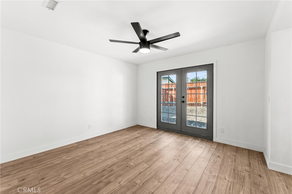 1423 Terrace Road Rialto, CA 92376 - Photo 21 of 40 an empty room with wooden floor fan and windows