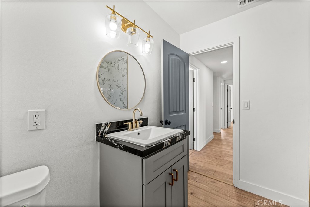 1423 Terrace Road Rialto, CA 92376 - Photo 30 of 40 a bathroom with a toilet a sink and a mirror