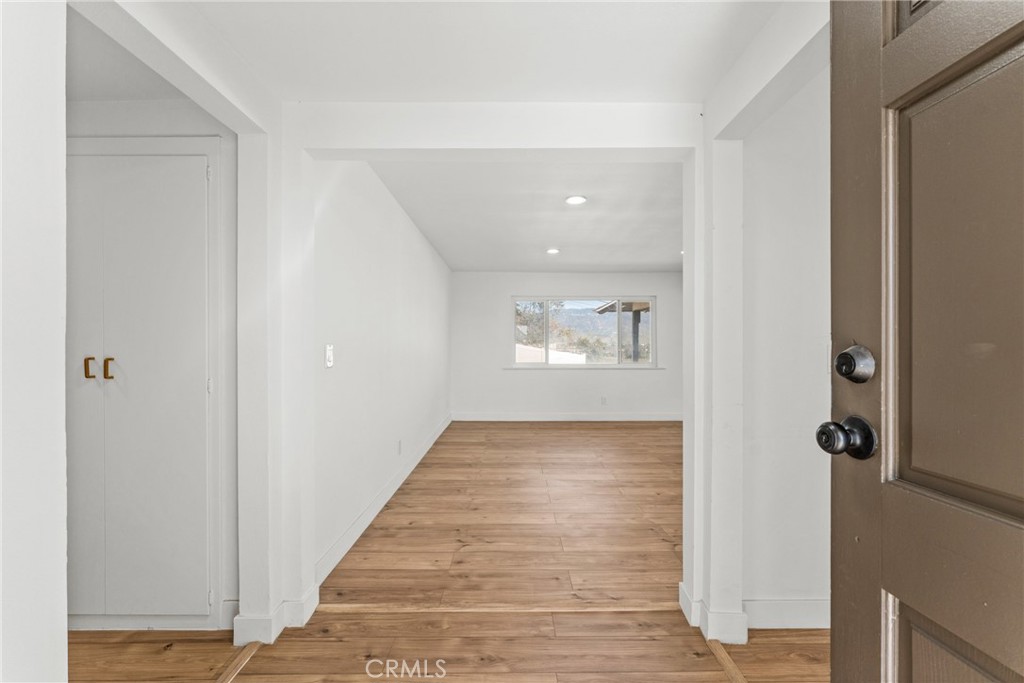 1423 Terrace Road Rialto, CA 92376 - Photo 5 of 40 a view of a hallway with wooden floor and a bathroom