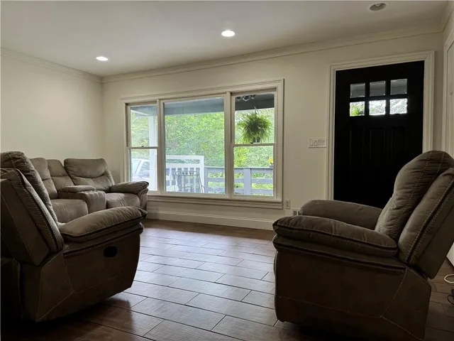 a view of kitchen with granite countertop dining table chairs cabinets and stainless steel appliances