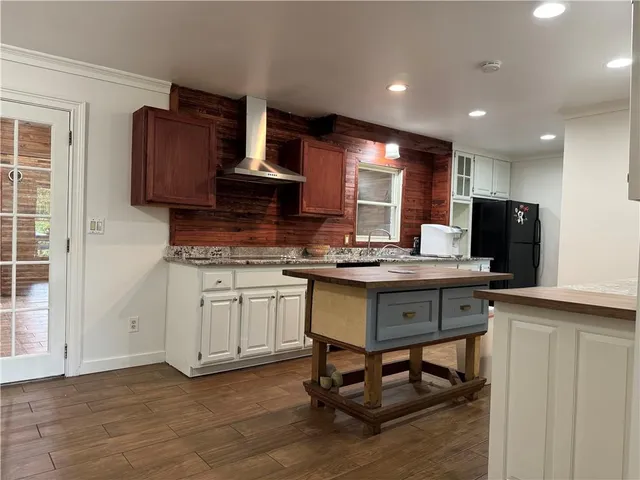 a view of kitchen with granite countertop window and white cabinets
