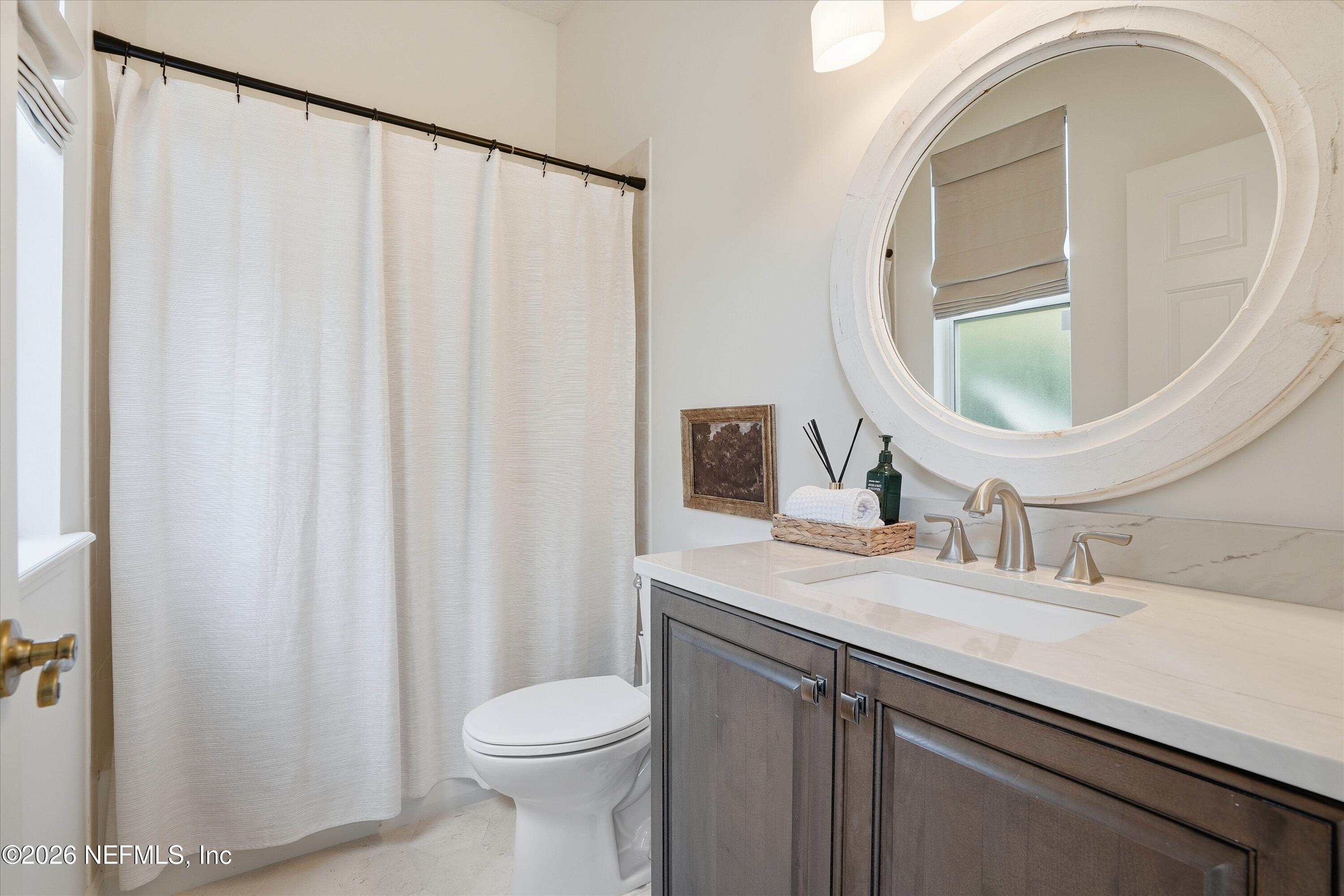 628 Pelham Road St. Augustine, FL 32092 - Photo 24 of 56 a bathroom with a granite countertop sink toilet and mirror