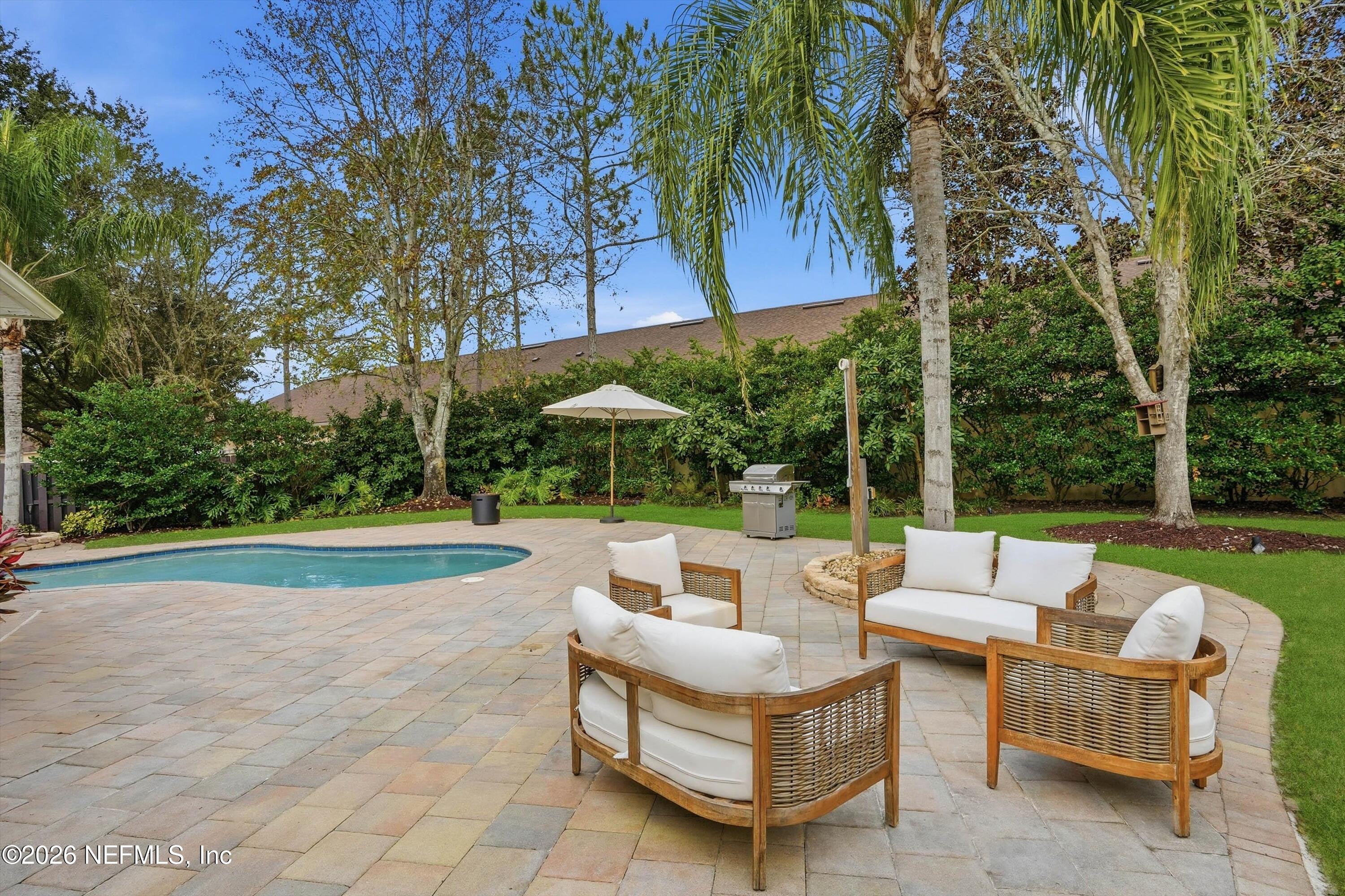 628 Pelham Road St. Augustine, FL 32092 - Photo 35 of 56 a view of patio with couches and table under an umbrella