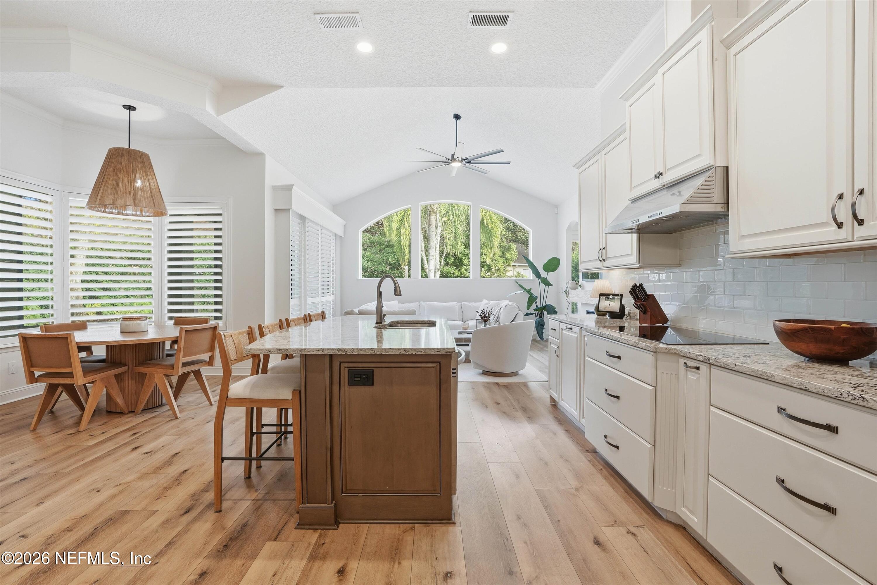628 Pelham Road St. Augustine, FL 32092 - Photo 10 of 56 a kitchen with stainless steel appliances a kitchen island hardwood floor sink stove dining table and chairs
