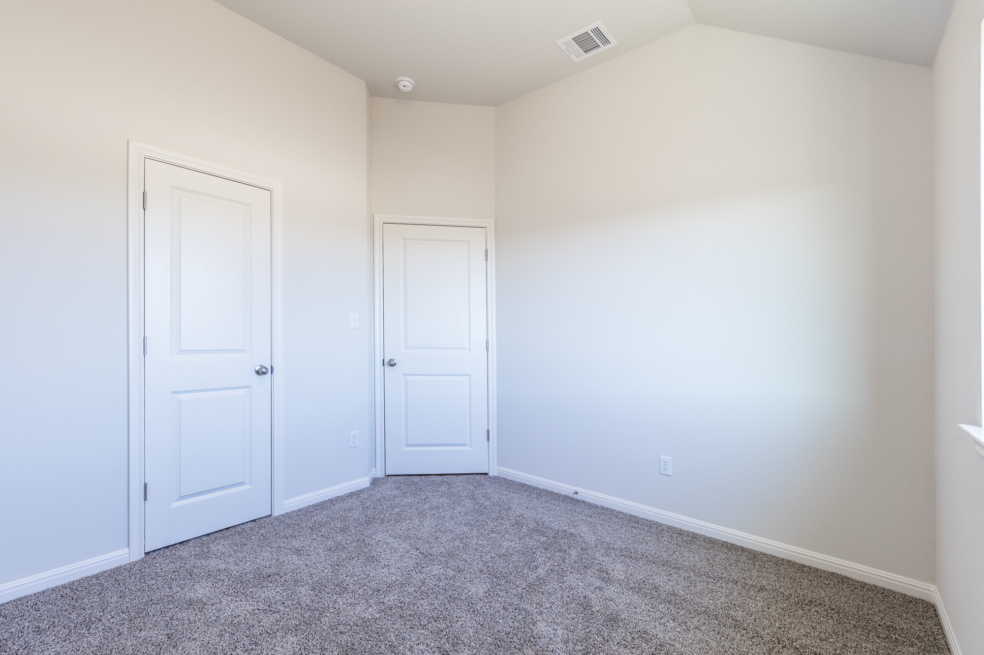 2725 Hopi Path Leander, TX 78641 - Photo 10 of 30 A spacious secondary bedroom, featuring soft carpet flooring and two solid panel doors.