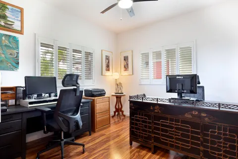 a view of a workspace with furniture and a window