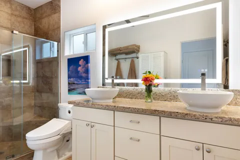 a bathroom with a granite countertop sink a toilet and shower