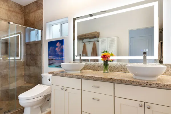 a bathroom with a granite countertop sink a toilet and shower