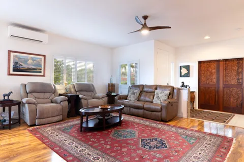 a living room with furniture ceiling fan and a rug