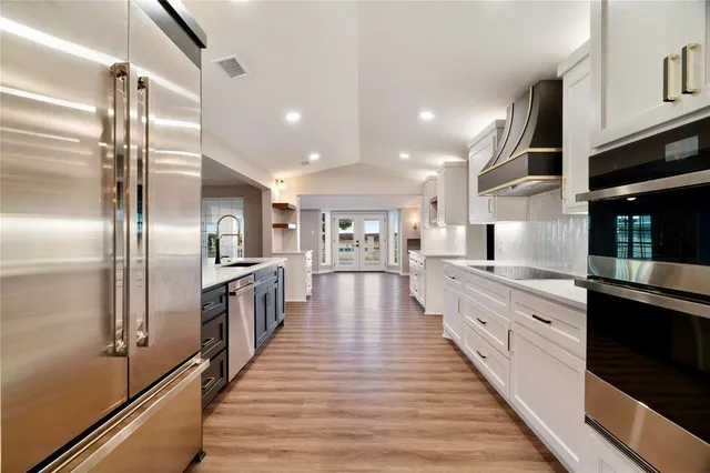 a view of an empty room with wooden floor and window