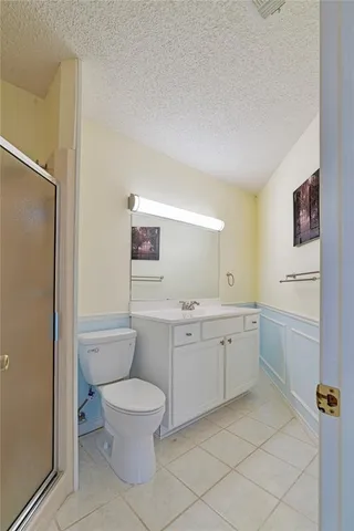 an empty room with wooden floor chandelier and windows