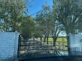 a big yard with trees in front of it