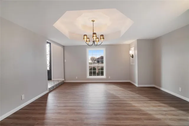 a view of empty room with wooden floor and window
