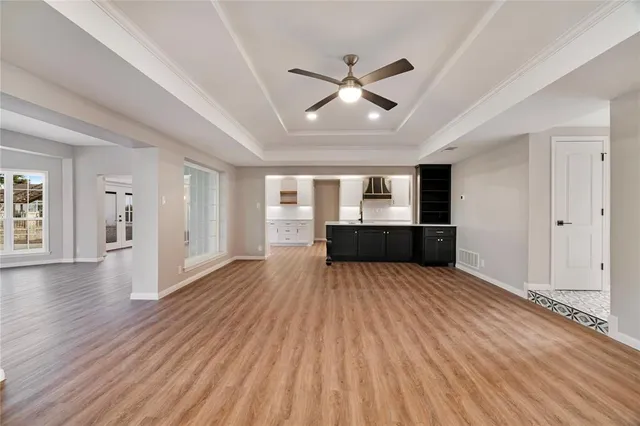 an empty room with wooden floor fireplace and windows