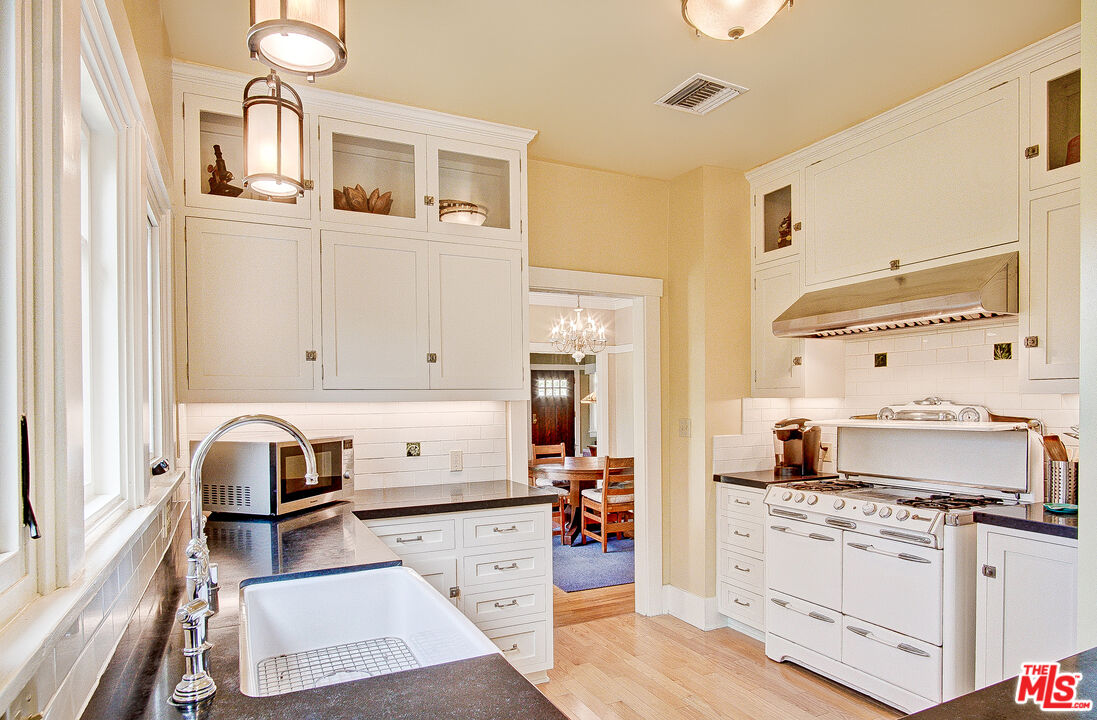 1204 Bresee Avenue Pasadena, CA 91104 - Photo 11 of 31 a kitchen with a stove cabinets and wooden floor