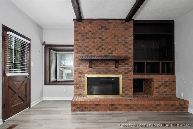 a living room with a fireplace furniture a flat screen tv and a fireplace