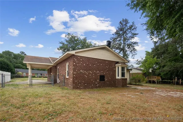 a front view of a house with a garden and trees