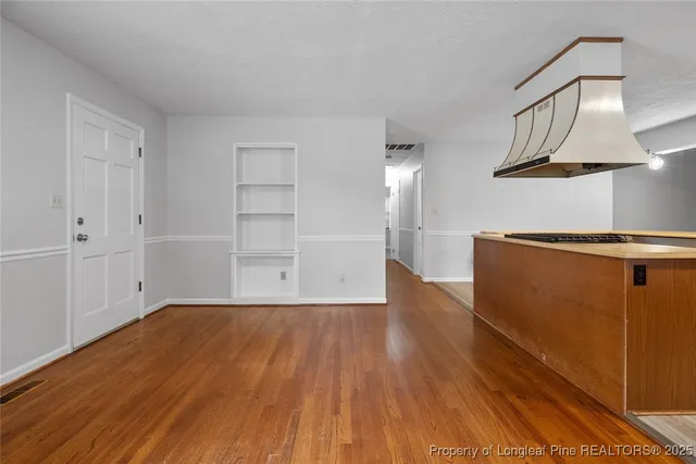 a view of a kitchen with wooden floor and cabinets
