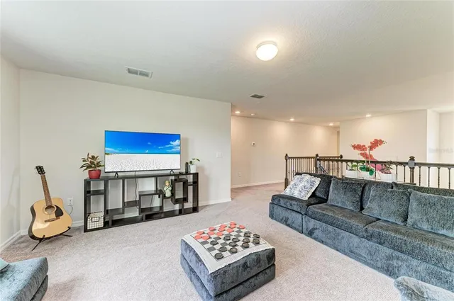 a living room with furniture a flat screen tv and a table