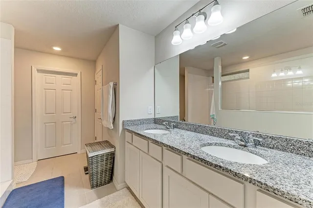 a bathroom with a granite countertop sink and a mirror