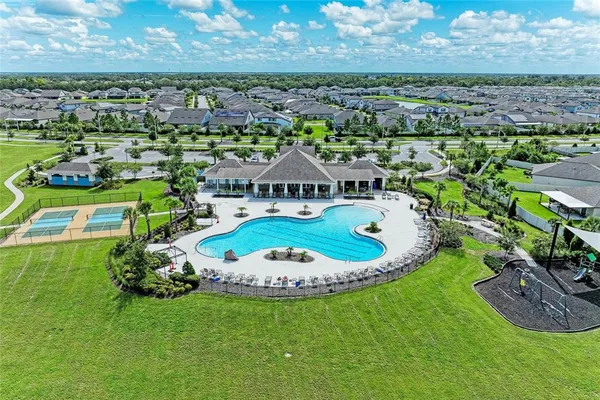an aerial view of a house with outdoor space and trees all around