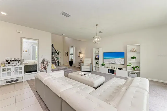 a large living room with stainless steel appliances kitchen island granite countertop a sink and a flat screen tv