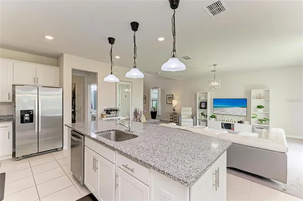 a large kitchen with kitchen island a sink stainless steel appliances and a counter space