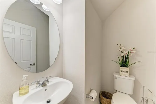 a bathroom with a toilet a sink and a mirror