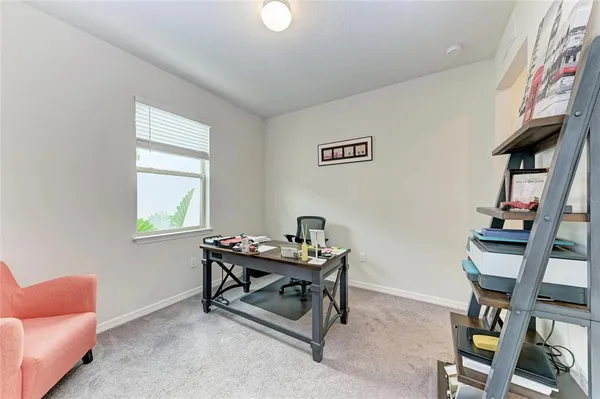 a view of a workspace with furniture and a window