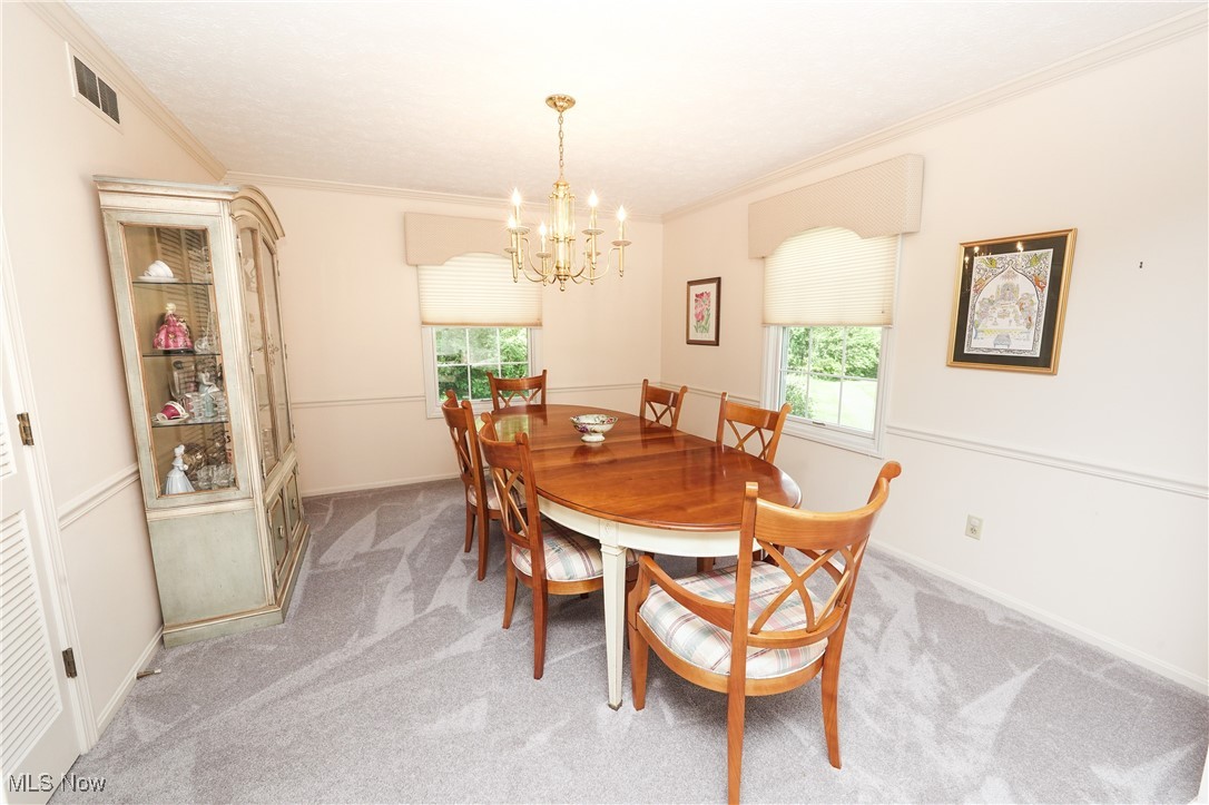 817 Rickel Circle Akron, OH 44333 - Photo 10 of 49 Dining area featuring crown molding, a chandelier, light grey carpet, and plenty of natural light