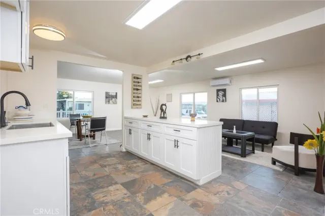 a large white kitchen with cabinets a sink and appliances