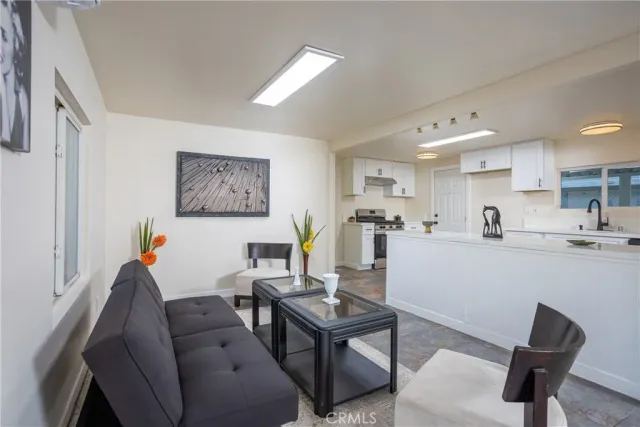 a living room with furniture and a dining table with wooden floor