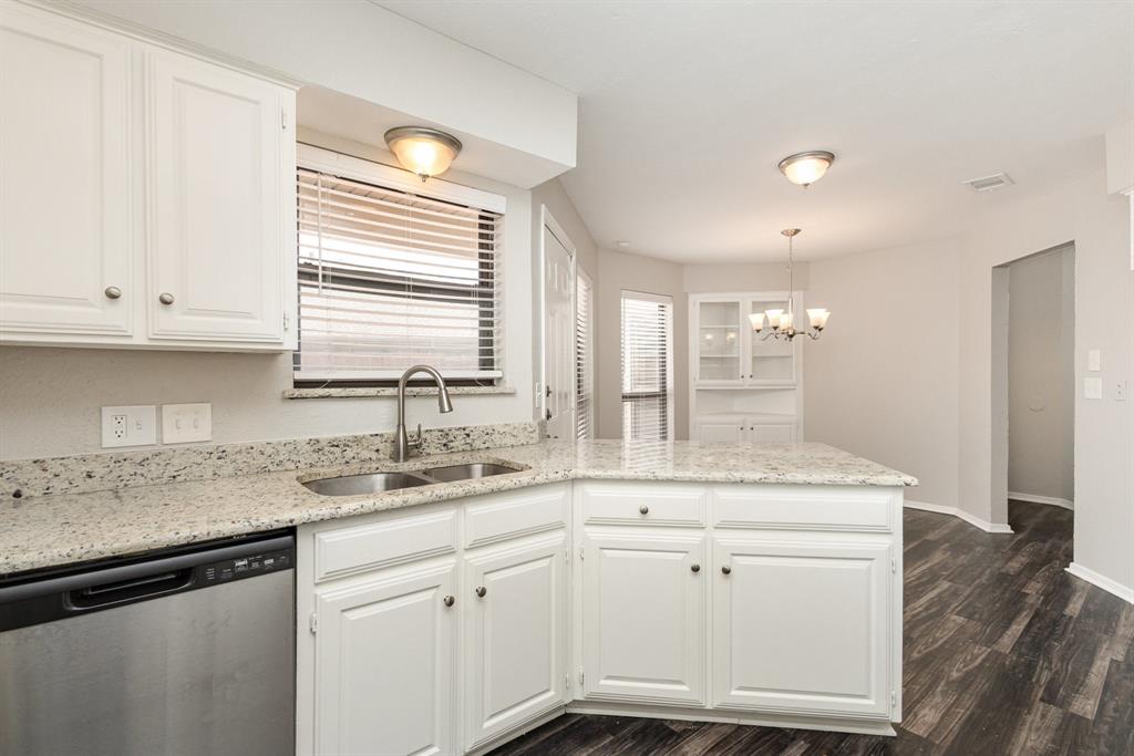 3104 Cross Bend Road Plano, TX 75023 - Photo 11 of 28 a kitchen with a sink dishwasher and white cabinets with wooden floor