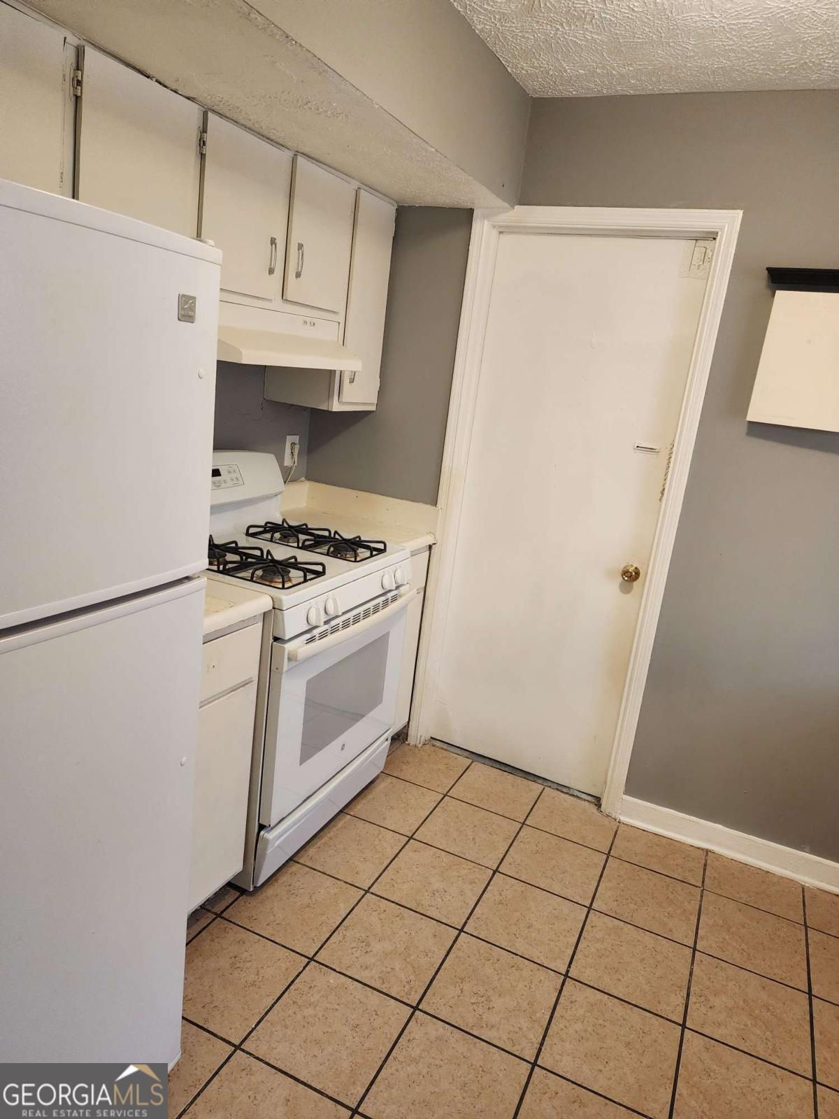 128 Cardinal Lane Jonesboro, GA 30238 - Photo 6 of 16 a kitchen with white cabinets and white appliances