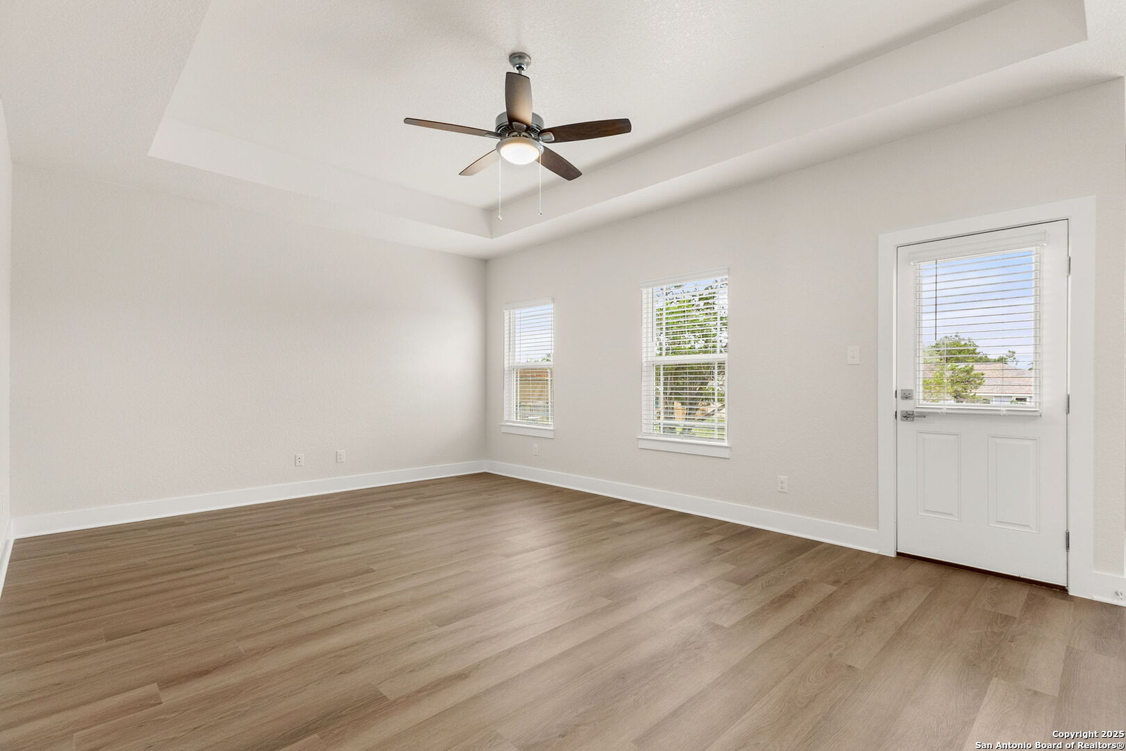 952 Rimrock Cove Spring Branch, TX 78070 - Photo 17 of 39 an empty room with wooden floor ceiling fan and windows