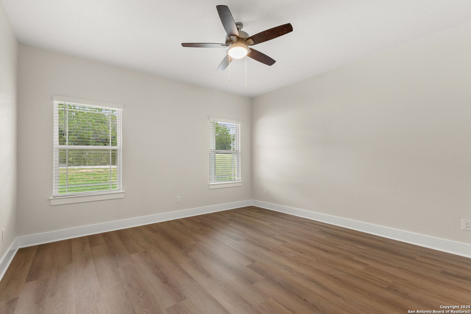 952 Rimrock Cove Spring Branch, TX 78070 - Photo 19 of 39 an empty room with wooden floor ceiling fan and windows