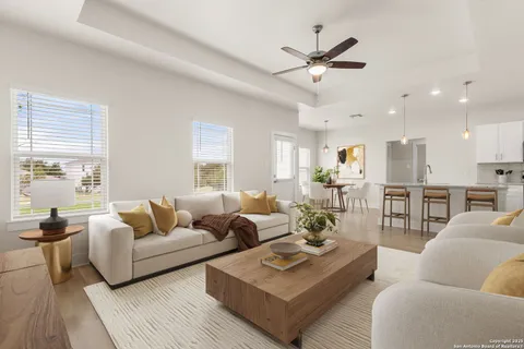 a living room with furniture kitchen view and a large window