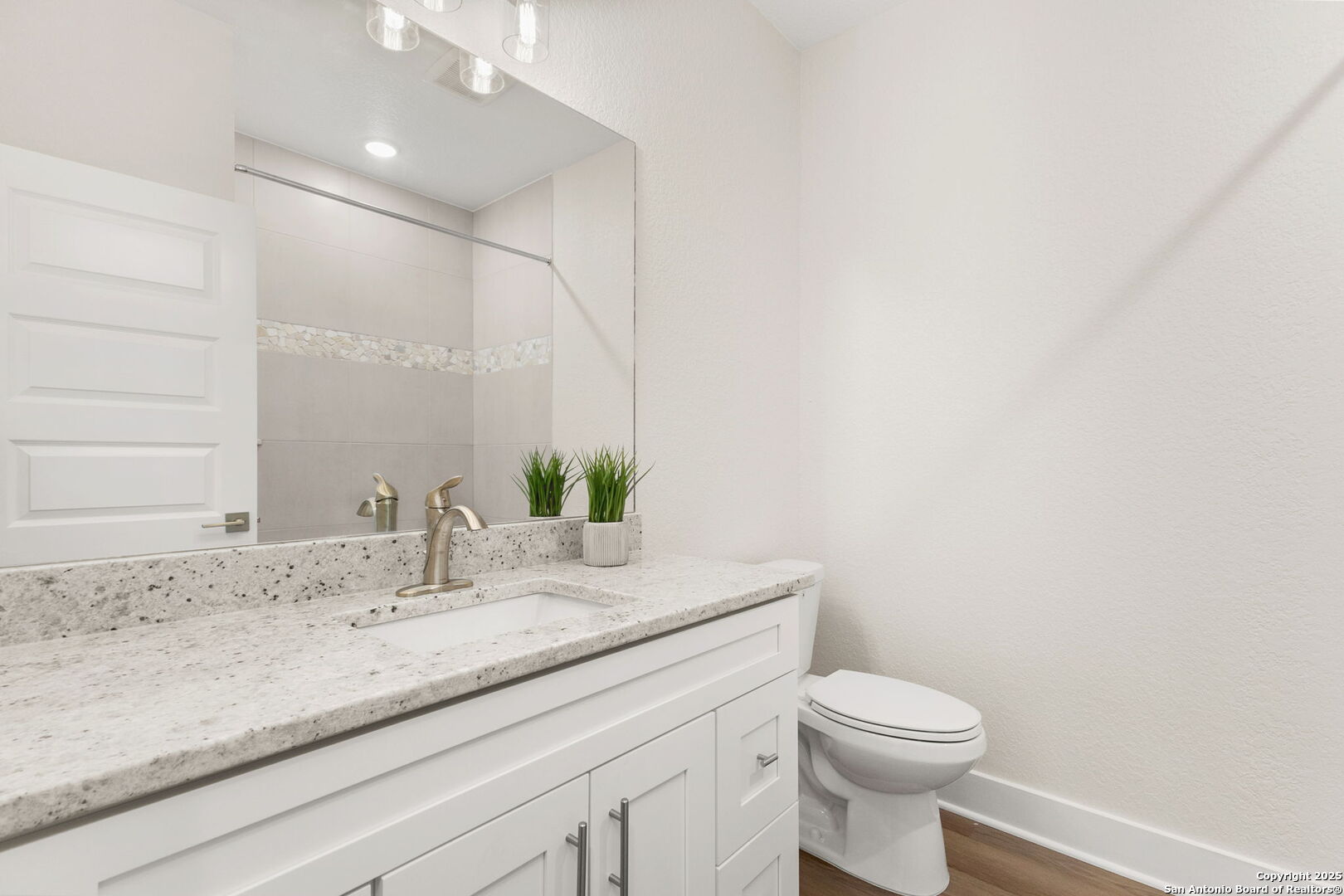 952 Rimrock Cove Spring Branch, TX 78070 - Photo 24 of 39 a bathroom with a granite countertop sink a toilet and mirror